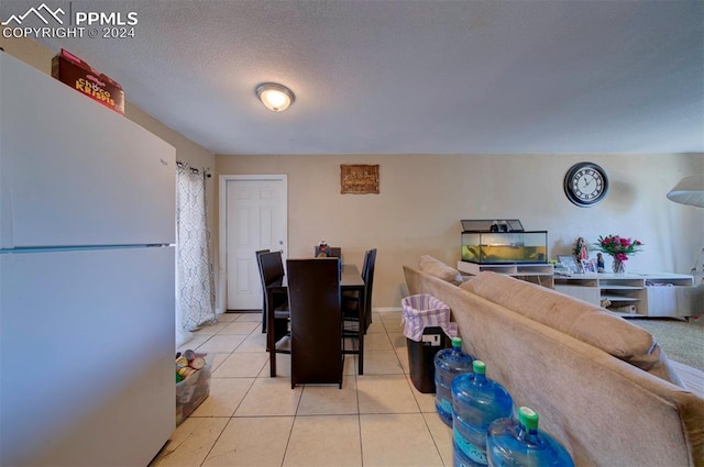 dining space with a textured ceiling and light tile patterned floors