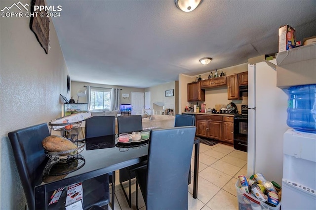 dining space with light tile patterned flooring and a textured ceiling