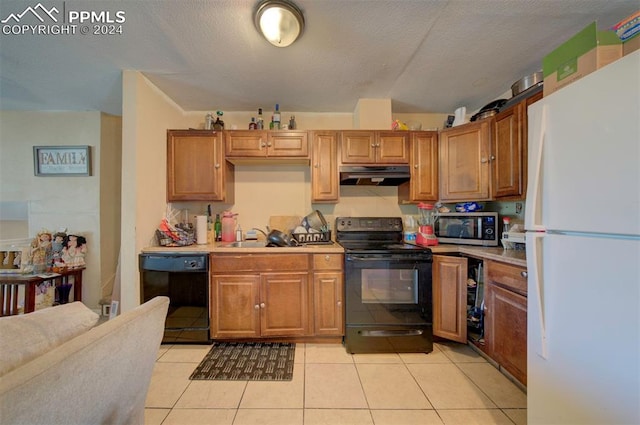 kitchen featuring a textured ceiling, black appliances, sink, and light tile patterned floors