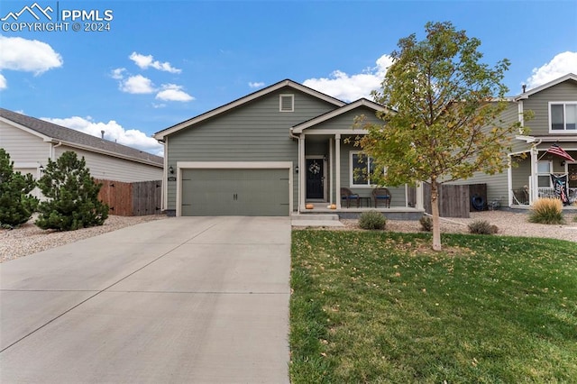 view of front facade with a garage, a front lawn, and a porch