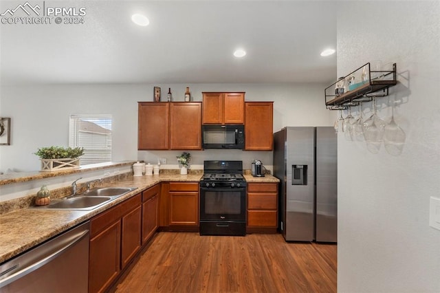 kitchen with light hardwood / wood-style flooring, black appliances, and sink