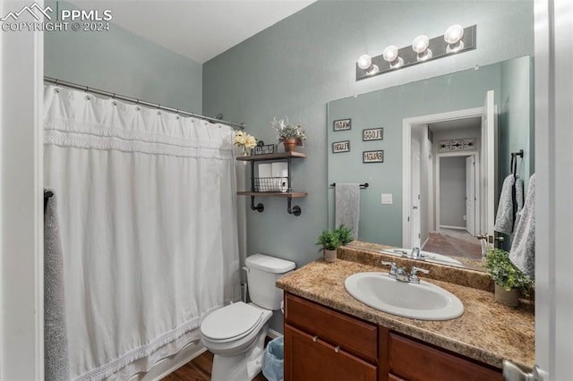 bathroom featuring vanity, hardwood / wood-style flooring, toilet, and walk in shower