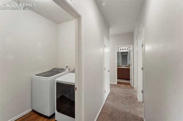 washroom with light carpet, sink, and separate washer and dryer