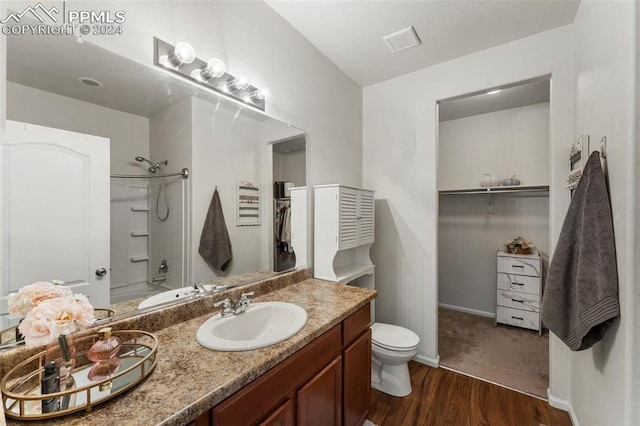 bathroom with toilet, hardwood / wood-style floors, and vanity