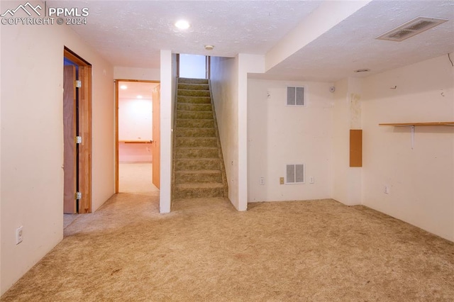 basement with light colored carpet and a textured ceiling