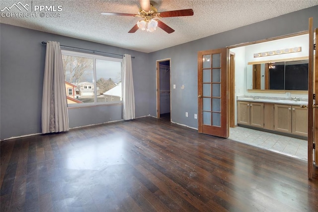 unfurnished room featuring ceiling fan, sink, wood-type flooring, and a textured ceiling