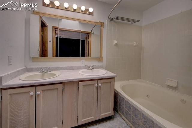 bathroom featuring tile patterned flooring, vanity, and tiled shower / bath