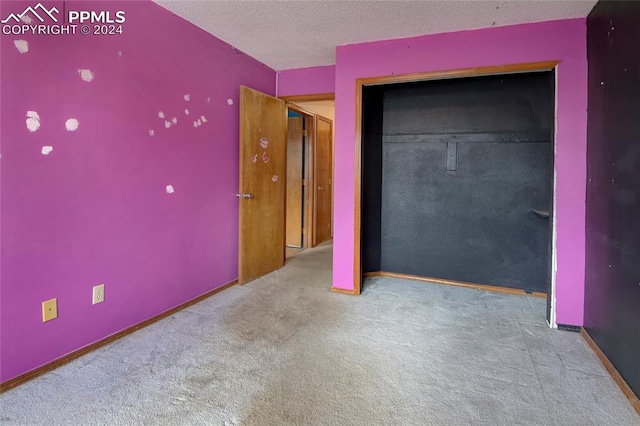 unfurnished bedroom featuring carpet flooring and a textured ceiling