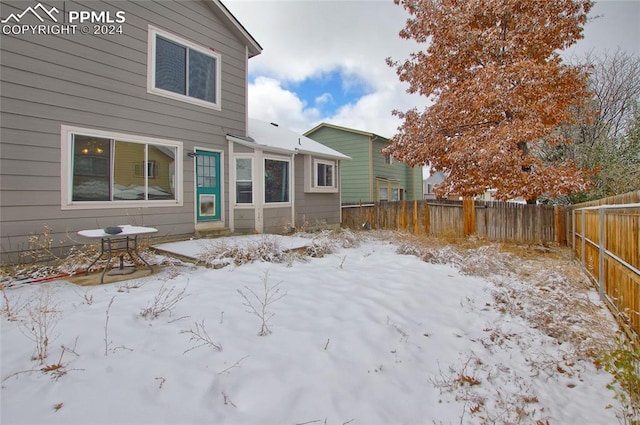 view of snow covered rear of property