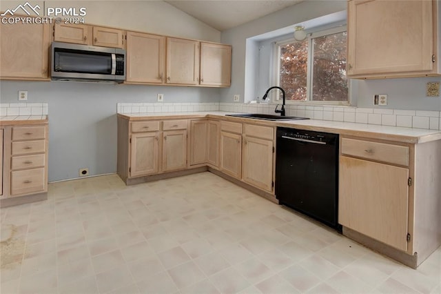 kitchen with sink, vaulted ceiling, black dishwasher, light brown cabinetry, and tile counters