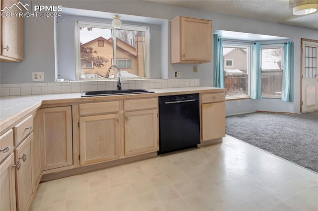 kitchen featuring tile countertops, dishwasher, light carpet, sink, and a textured ceiling