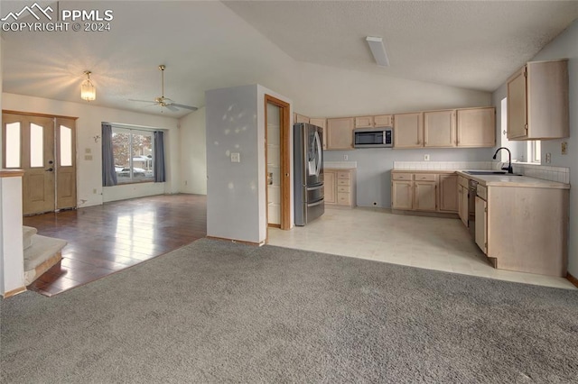 kitchen featuring ceiling fan, light brown cabinets, sink, lofted ceiling, and appliances with stainless steel finishes