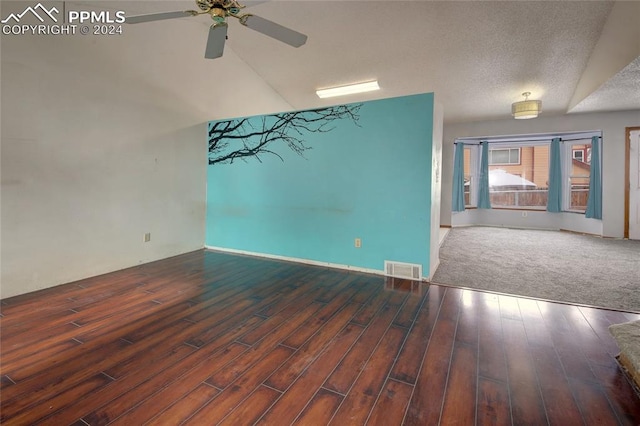 empty room with vaulted ceiling, ceiling fan, a textured ceiling, and hardwood / wood-style flooring