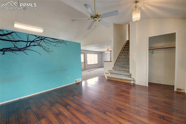 unfurnished living room featuring a textured ceiling, hardwood / wood-style flooring, vaulted ceiling, and ceiling fan