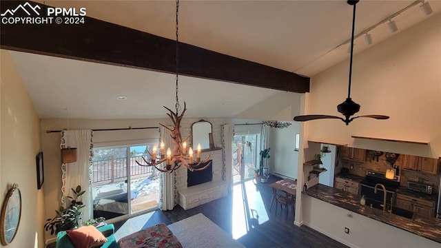 dining space featuring sink, ceiling fan with notable chandelier, vaulted ceiling with beams, and dark hardwood / wood-style floors