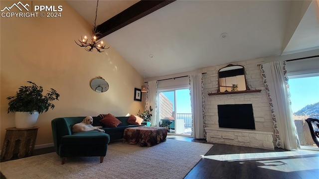 living room featuring a stone fireplace, high vaulted ceiling, an inviting chandelier, and hardwood / wood-style flooring