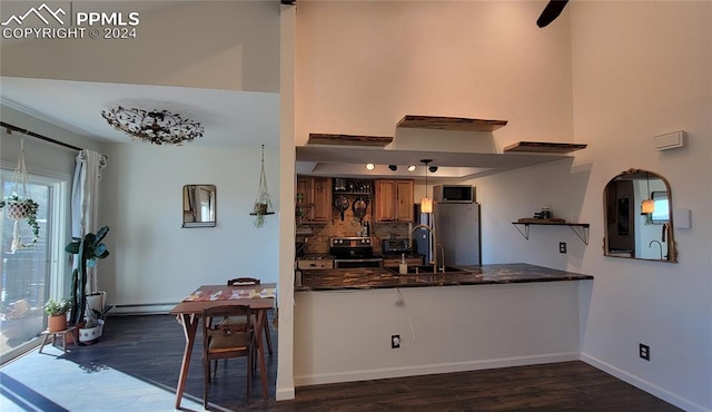 kitchen featuring appliances with stainless steel finishes, kitchen peninsula, dark hardwood / wood-style flooring, and sink