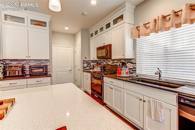 kitchen with white cabinets, black appliances, and sink