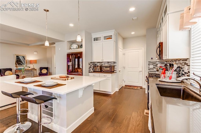 kitchen with decorative backsplash, white cabinetry, stainless steel appliances, and pendant lighting