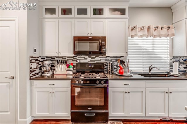 kitchen featuring white cabinetry, tasteful backsplash, black appliances, and sink