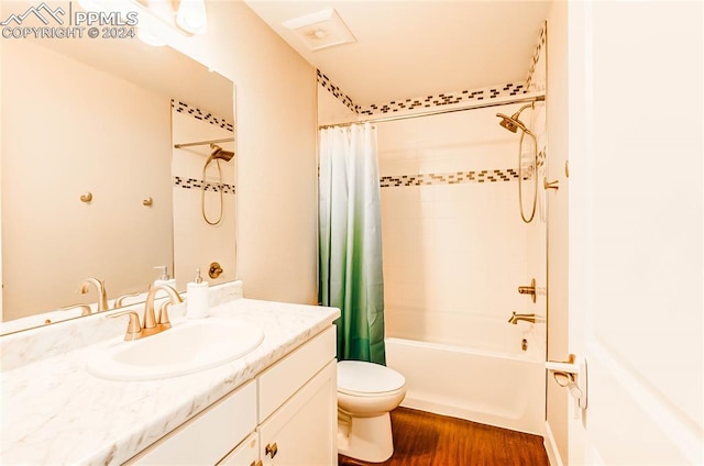 full bathroom with toilet, hardwood / wood-style floors, vanity, and shower / bath combo