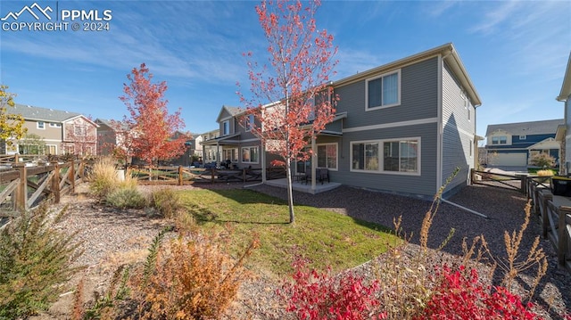 back of property featuring a patio and a yard