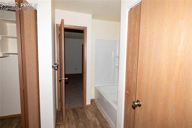 bathroom with wood-type flooring and a bath