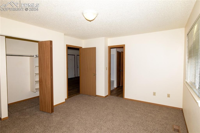 unfurnished bedroom with a closet, a textured ceiling, and carpet