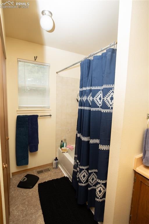 bathroom featuring vanity, tile patterned flooring, and shower / tub combo