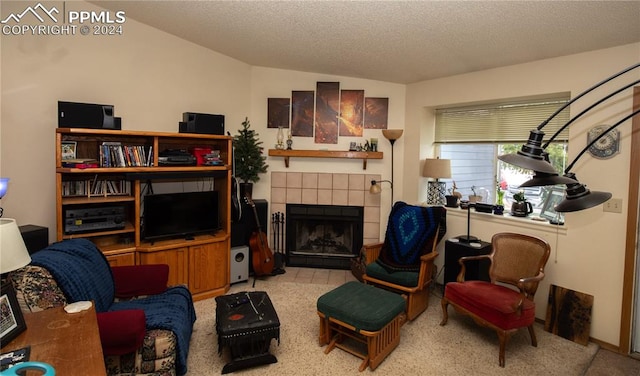 interior space with light carpet, lofted ceiling, a textured ceiling, and a tiled fireplace