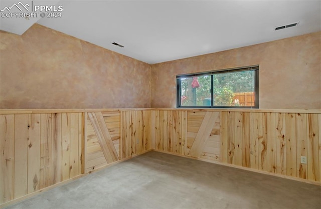 empty room with wood walls and carpet