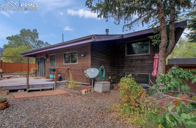 rear view of house featuring a wooden deck