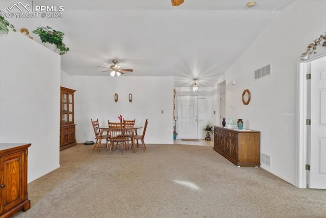 carpeted dining space featuring lofted ceiling and ceiling fan