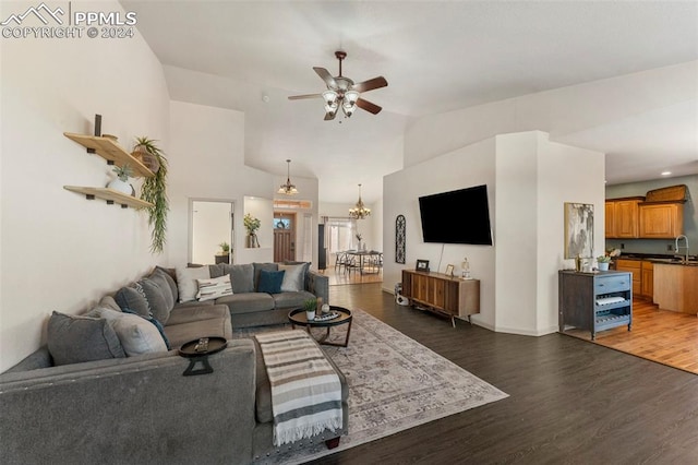 living room with lofted ceiling, sink, dark wood-type flooring, and ceiling fan with notable chandelier