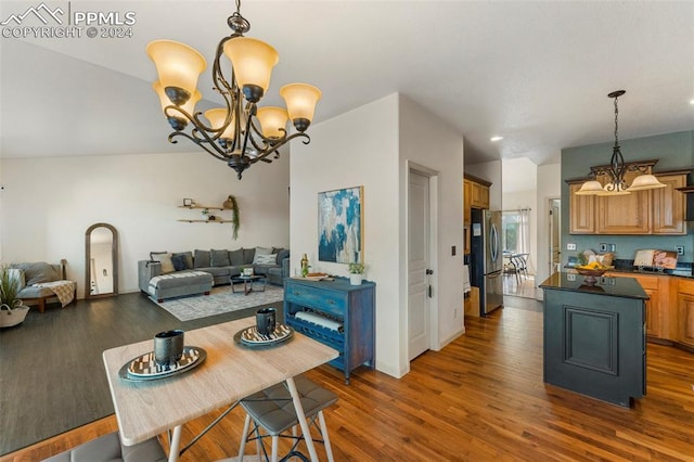 dining space featuring lofted ceiling, dark wood-type flooring, and a chandelier