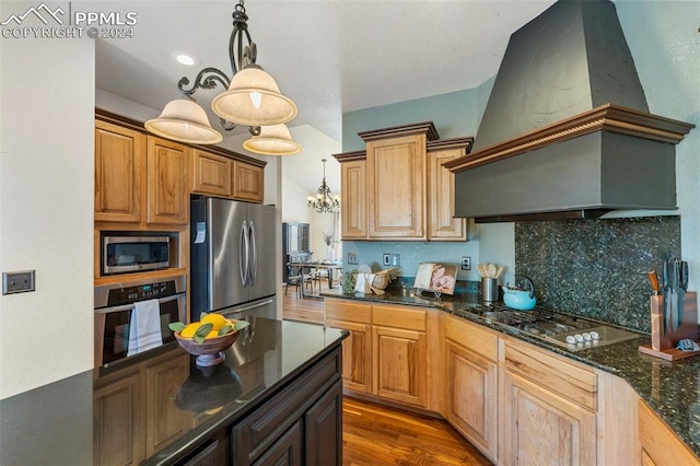 kitchen with custom exhaust hood, hardwood / wood-style floors, stainless steel appliances, and hanging light fixtures