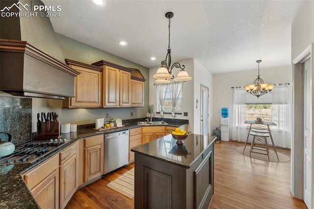 kitchen featuring dishwasher, a kitchen island, wood-type flooring, black gas cooktop, and decorative light fixtures