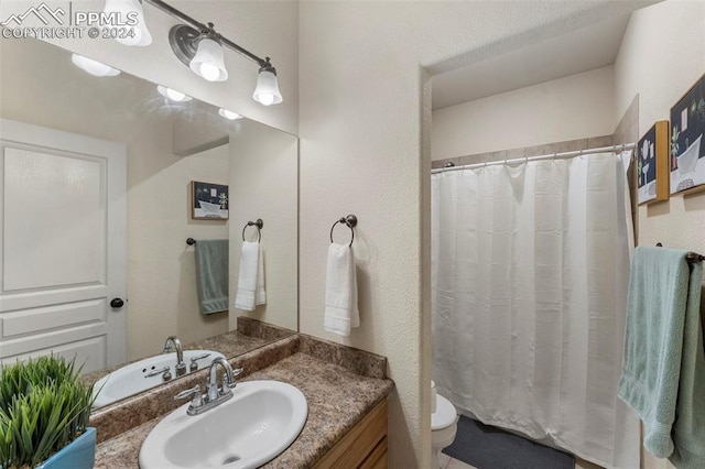 bathroom with vanity, toilet, and walk in shower