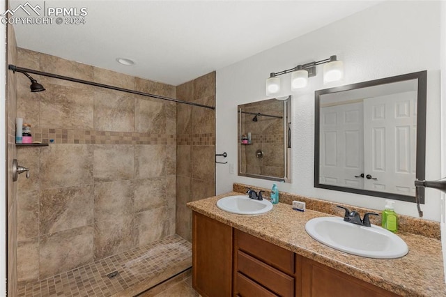 bathroom with vanity and a tile shower