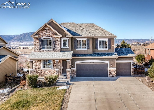 view of front of house with a mountain view, a garage, and a front yard