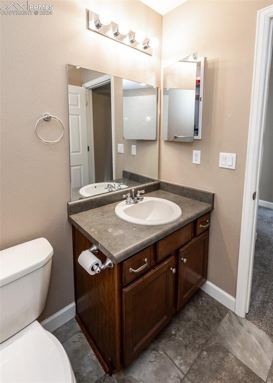 bathroom featuring tile patterned floors, vanity, and toilet