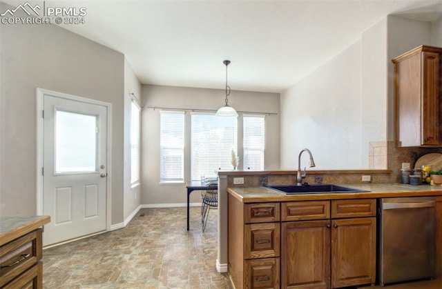 kitchen featuring dishwasher, tasteful backsplash, pendant lighting, and sink