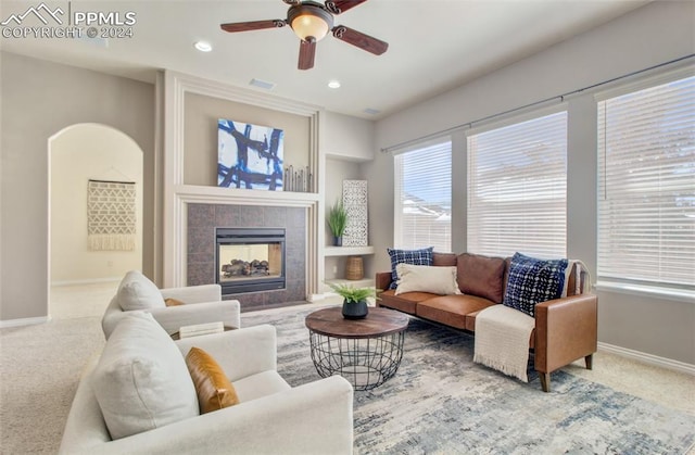 living room featuring a fireplace, carpet floors, and ceiling fan