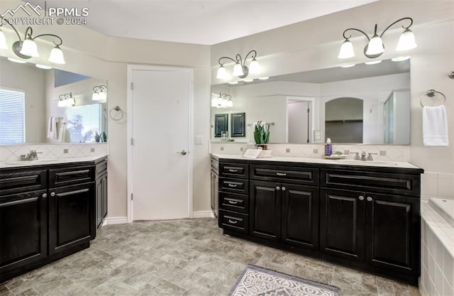 bathroom with vanity, a bathing tub, and tasteful backsplash