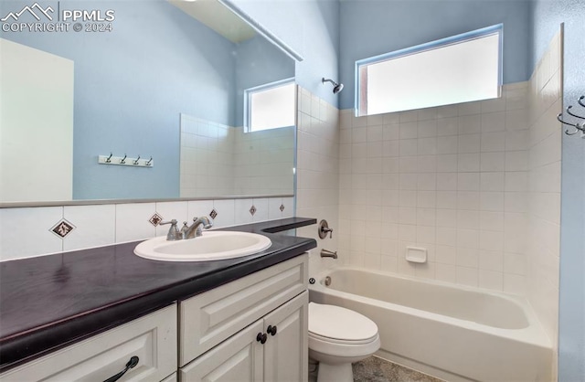 full bathroom featuring toilet, vanity, backsplash, and tiled shower / bath