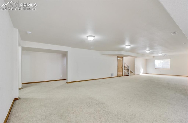 basement featuring light colored carpet