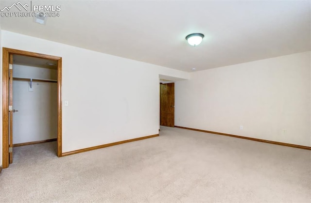 unfurnished bedroom with light colored carpet and a closet