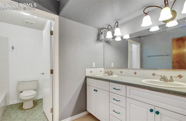 bathroom with tile patterned flooring, tasteful backsplash, a textured ceiling, vanity, and toilet