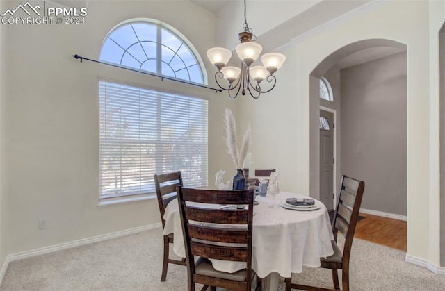 carpeted dining space featuring a notable chandelier