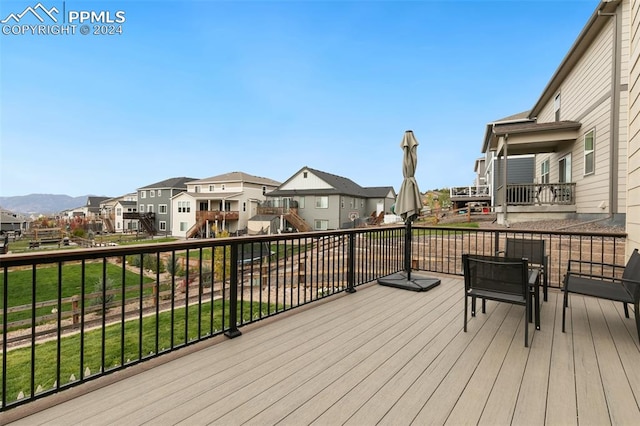 wooden terrace with a mountain view and a lawn